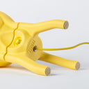 A detail of the underside of the Visitor table lamp in Lemon-Dip, we can see the logo and the cloth-covered cord entering the brass inlet.